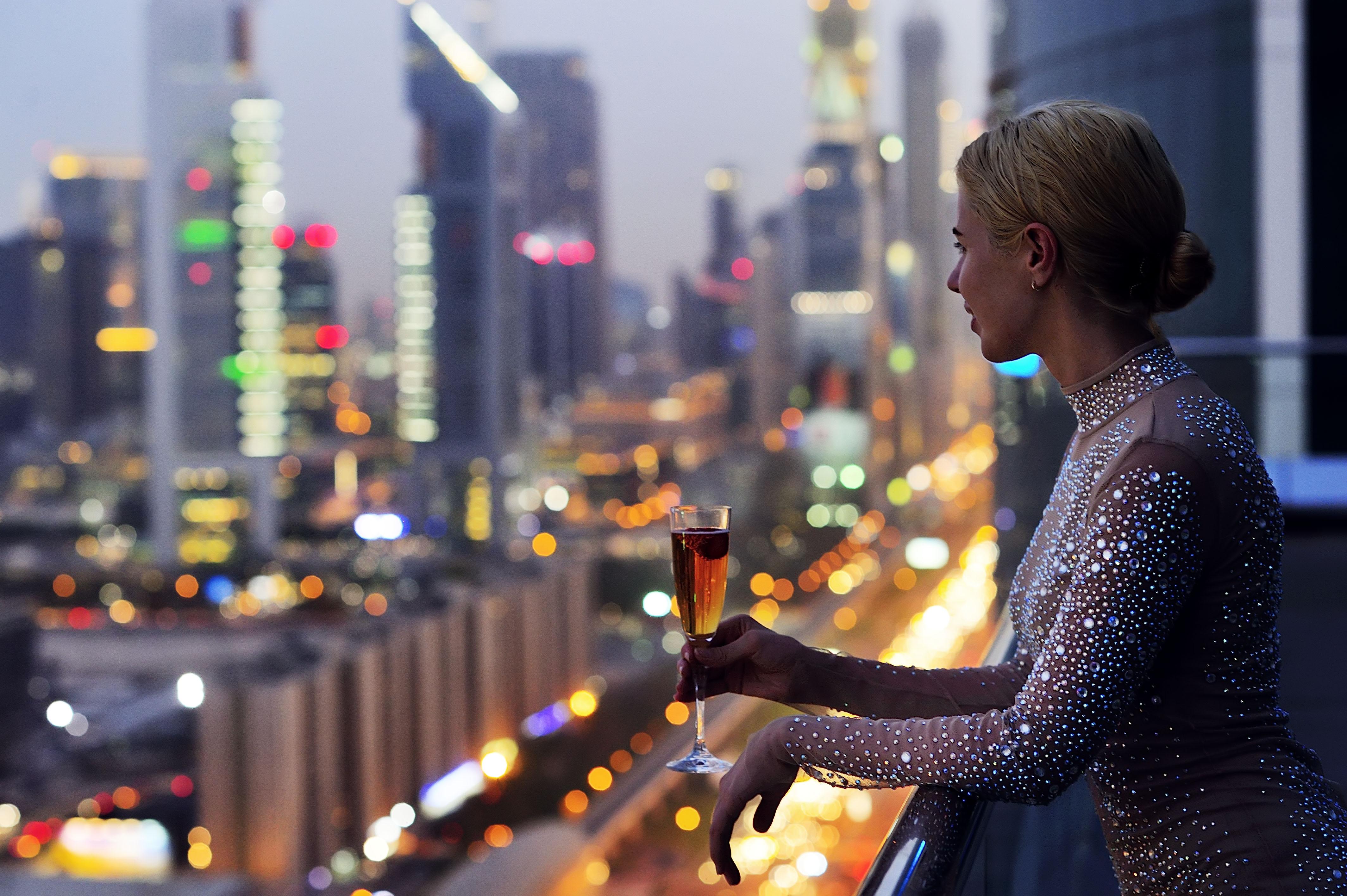 The H Dubai Hotel Exterior photo A woman drinking champagne